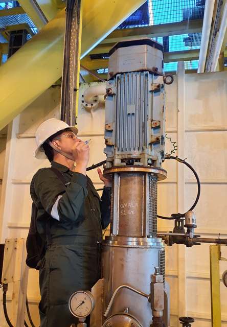 Technician performing remote vibration monitoring on rotating equipment
