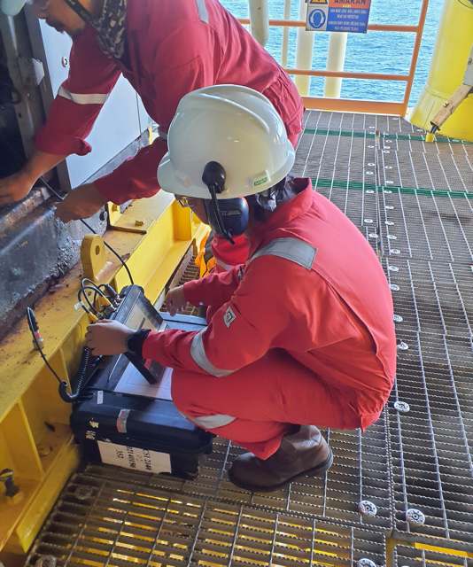 Technician performing ultrasound inspection on plant equipment