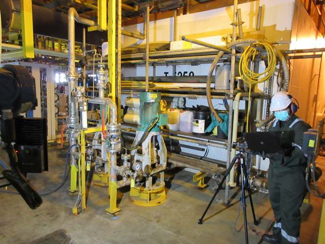 Technician conducting motion amplification analysis with camera and tripod